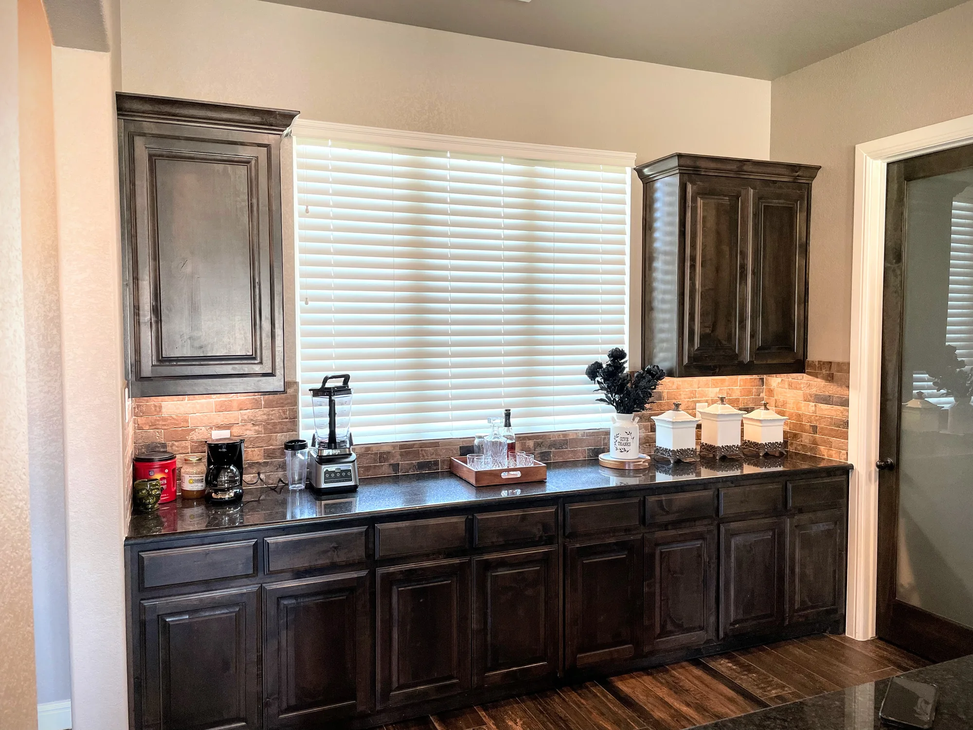 White faux wood blinds over a Texas kitchen sink