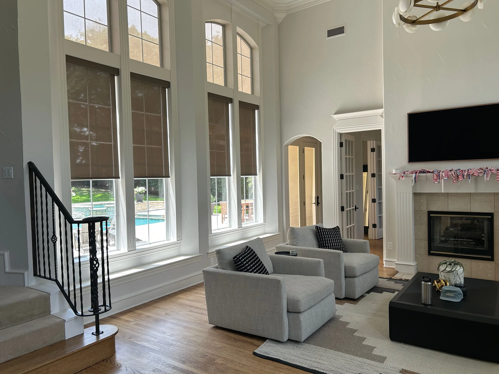 Motorized roller shades in a bright living room overlooking a pool